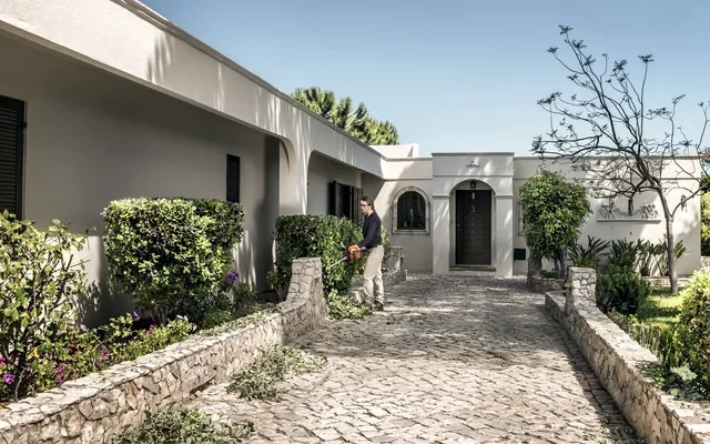 Domaćica obrezuje živicu u dvorištu sa Husqvarna škarama